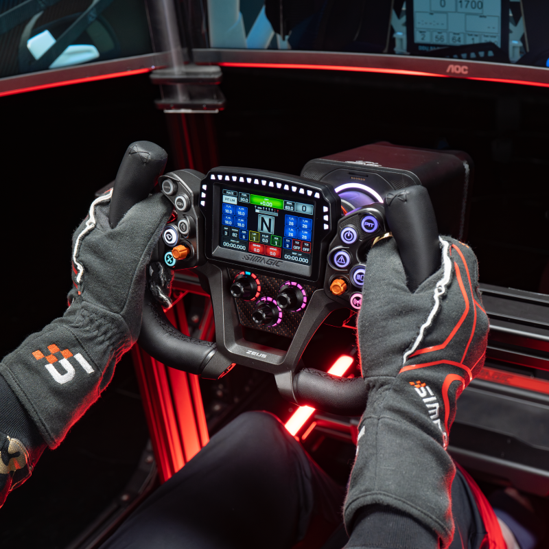 Driver using a Simagic Zeus GT steering wheel with MagicDash 4 powered on, fitted to a racing simulator